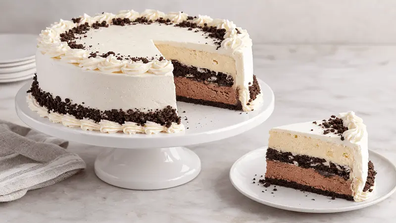 Round ice cream cake with a cut slice showing the layers and serving portion