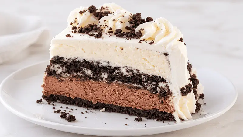 Ice cream cake slice showing vanilla ice cream, chocolate cookie crunch, and chocolate layers
